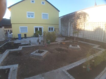 Terrasse mit Beeteinfassungen und Rasenfläche