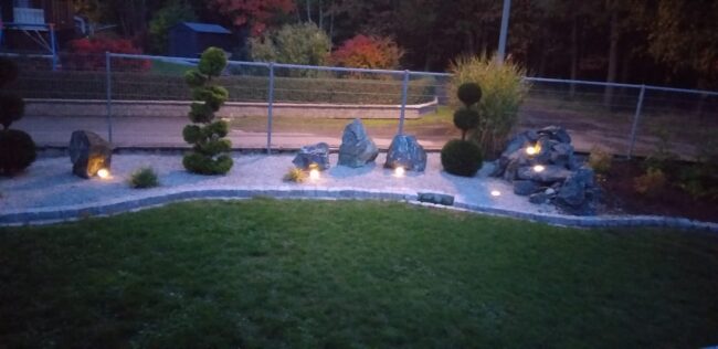 Heckenanlage mit Granitbruch zu Abendzeit